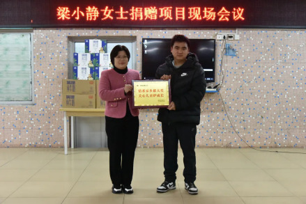 李媚向梁小静的代表人梁雀平先生颁发了牌匾