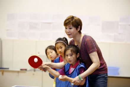 曹燕华手把手教小学员打乒乓球